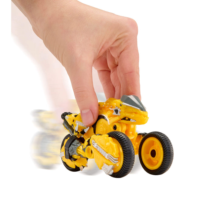 Yellow toy motorcycle with black wheels being held by a hand on a white background
