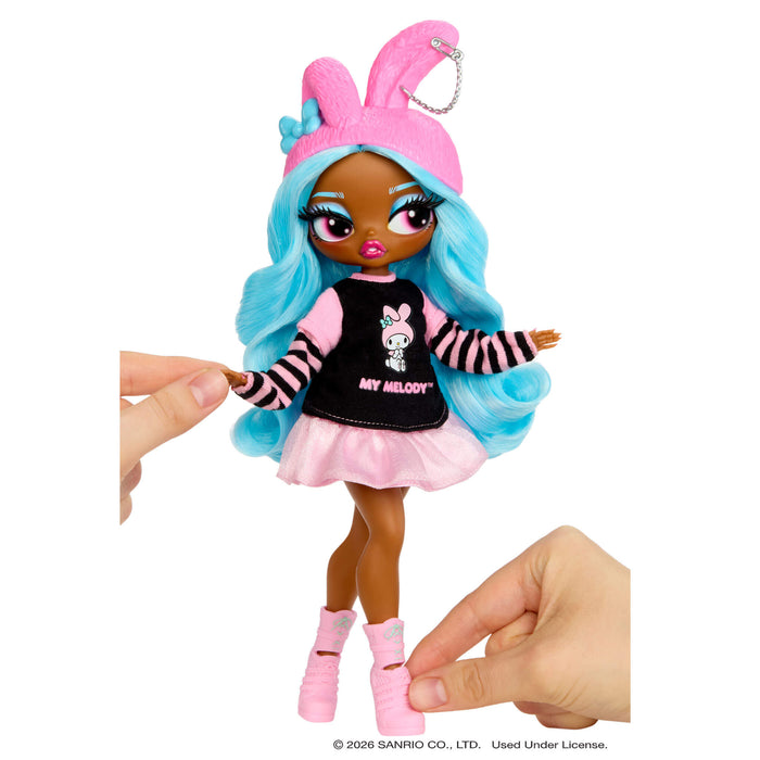 Toy doll with pink bunny ears and blue hair held by a hand on a white background