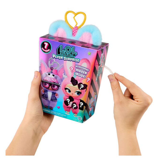 Hand holding a L.O.L. Surprise! plush toy packaging with colorful design.