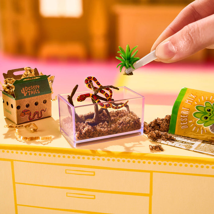 Miniature terrarium setup with a snake and plants on a colorful background